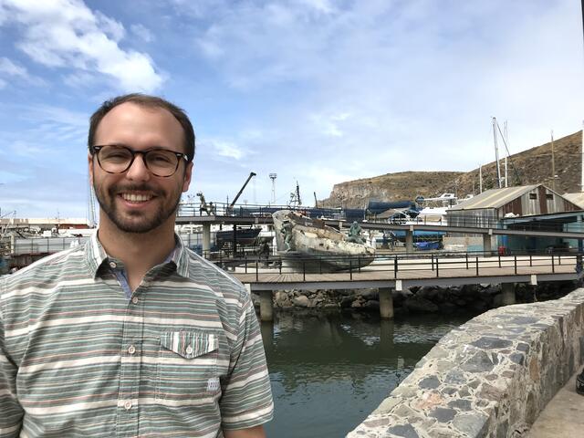 Alum Jason Swartz '18 standing at a marina.