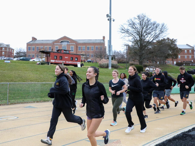 Students in Find Your Strong: Running for Your Life jog on a track.