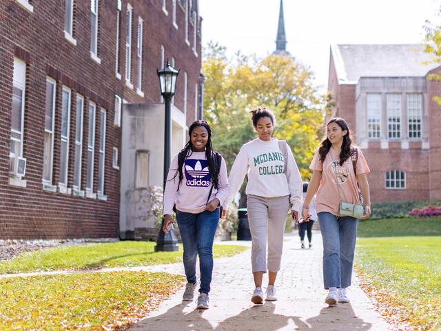 Photo of three students walking together on campus.