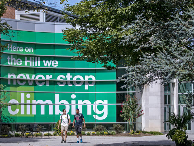 2 students walking in front of Gill Center