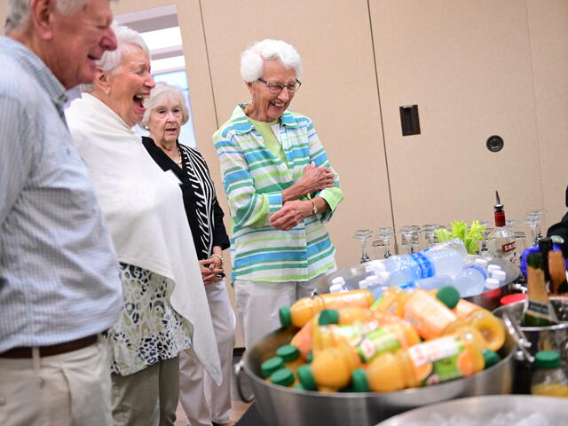 Group of adults standing at a table full of beverages