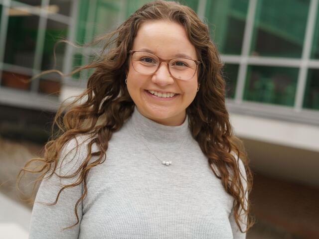 Headshot of Mackenzie McCarter outside the student center wearing a grey shirt.