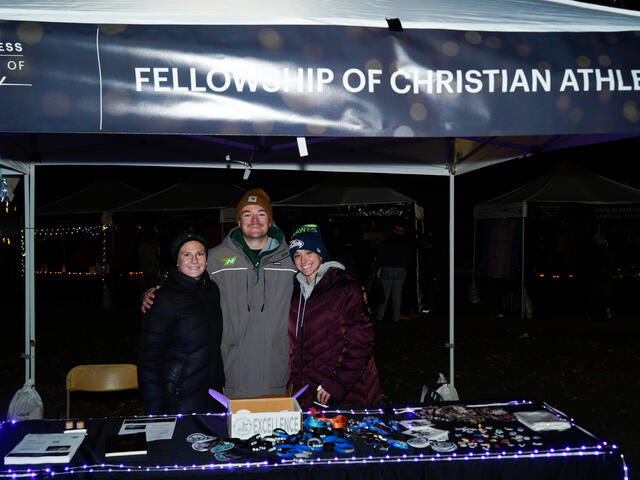 students pose under a banner reading "Fellowship of Christian Athletes"