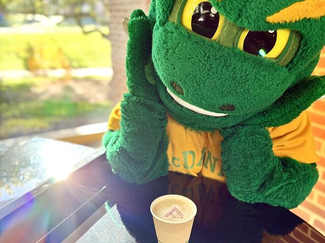 The Green Terror admiring a cup of coffee.
