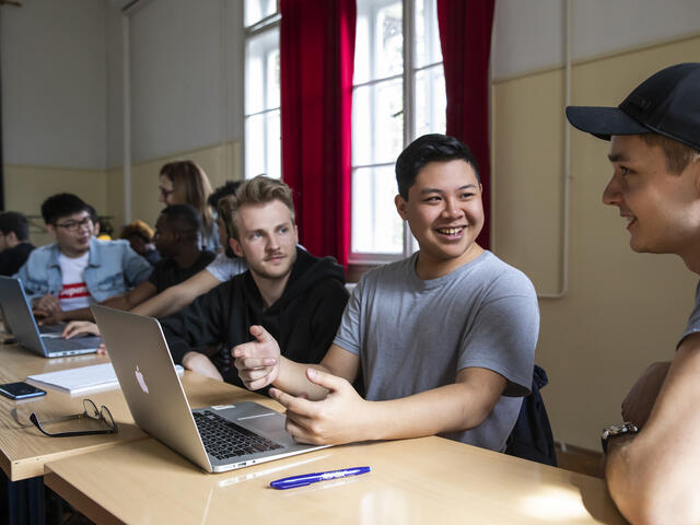 students in classroom discussing assignment