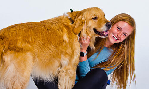 Morgan Collinson, petting a golden retriever