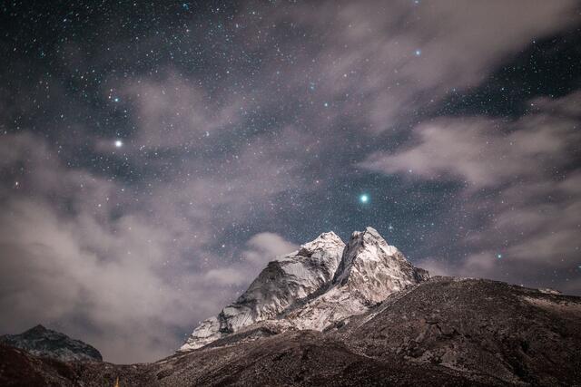 Clouds and stars over a mountain
