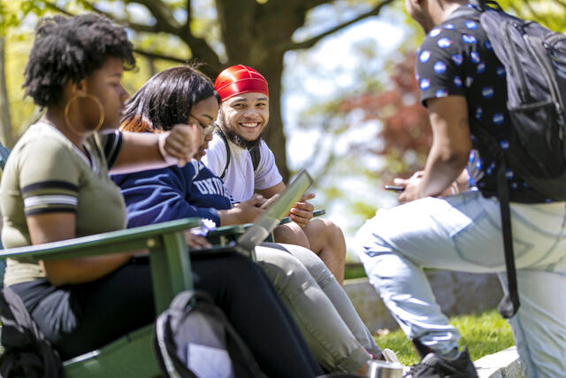 Students sitting in outdoor chairs on campus.