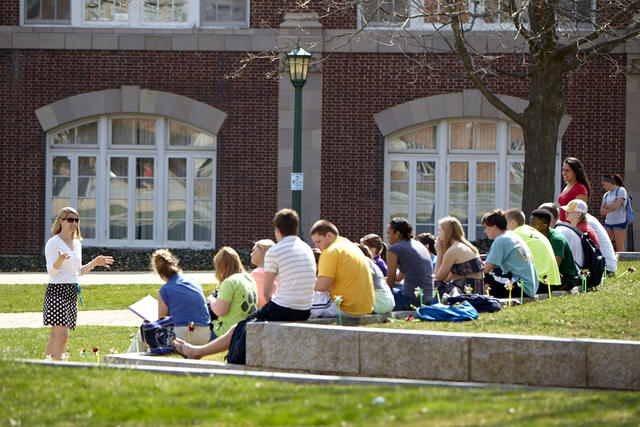 Professor lecturing class outdoors.