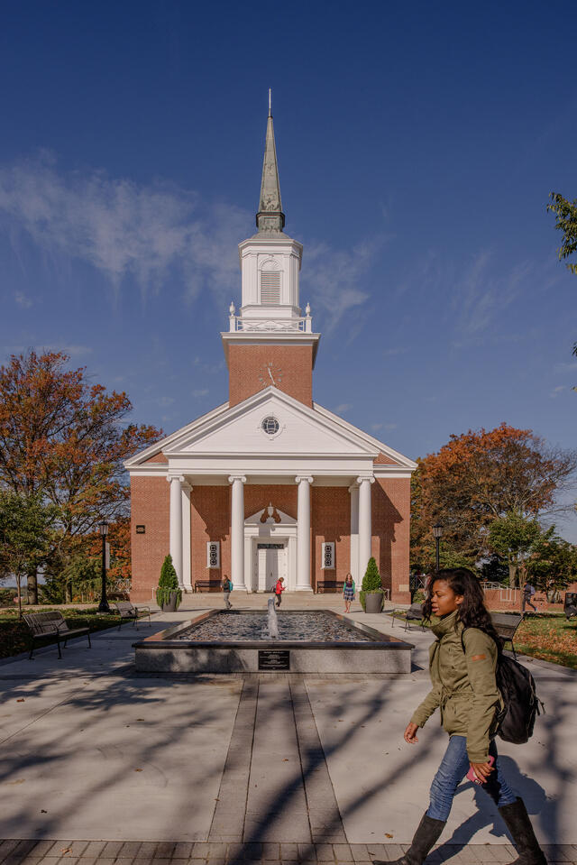 Student walking in front of Baker Memorial Chapel.