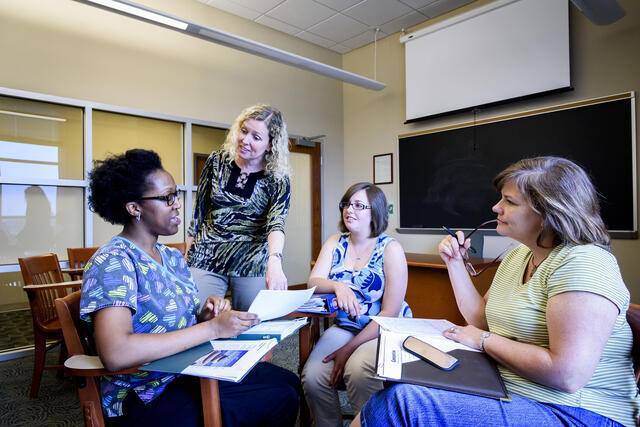 Grad professor interacting with students.