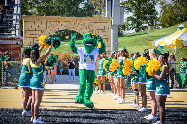Green Terror mascot with cheerleaders.