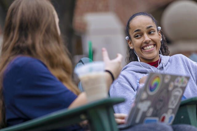 Students sitting in outdoor chairs on campus.