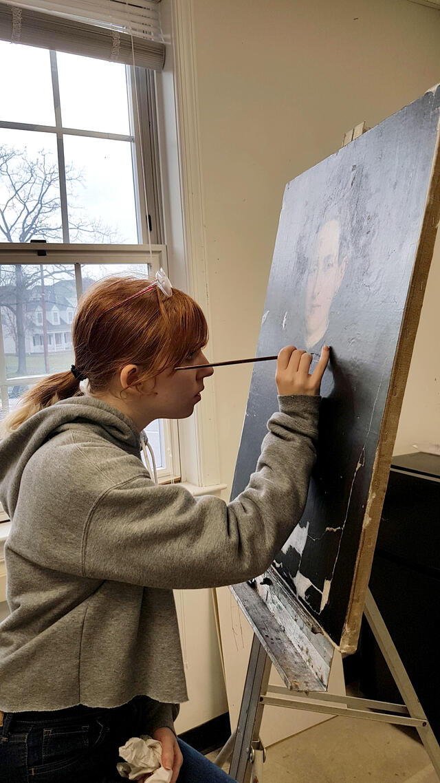 Freshman Stephanie Eckard works on retouching missing areas of paint.
