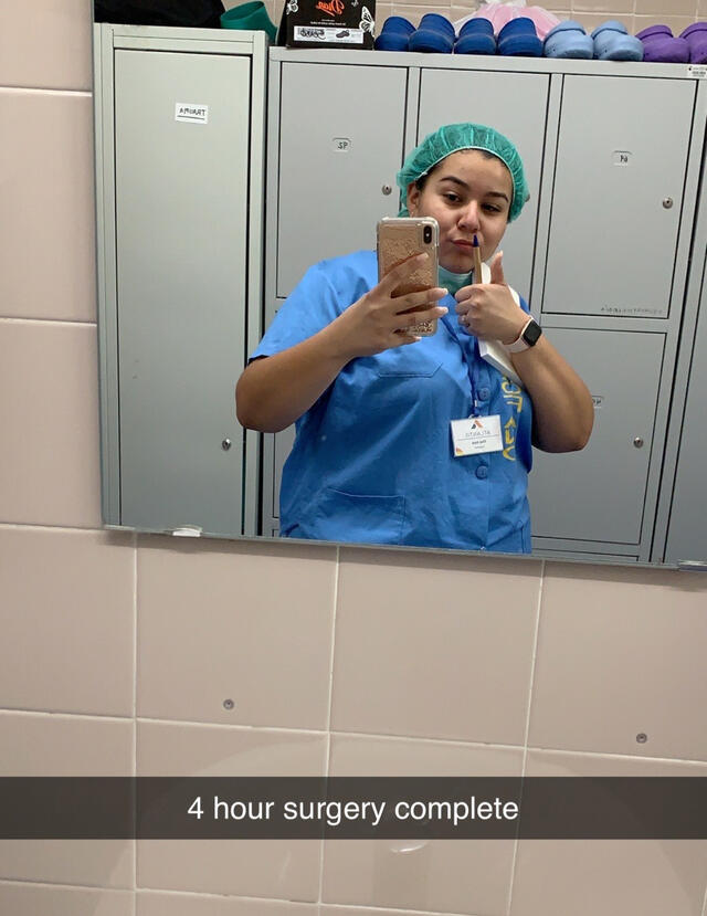 Sophomore Elva Joy in scrubs after 4 hour surgery