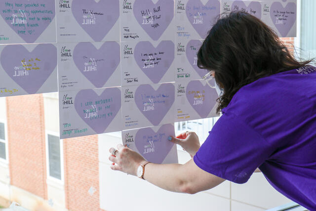 Presley Farve, enrollment division events manager, places a heart on the window.