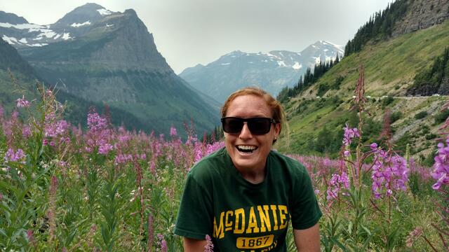 Ellen Larson '10 poses in field of wildflowers