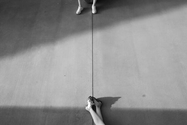 black and white photograph of feet on wood floor