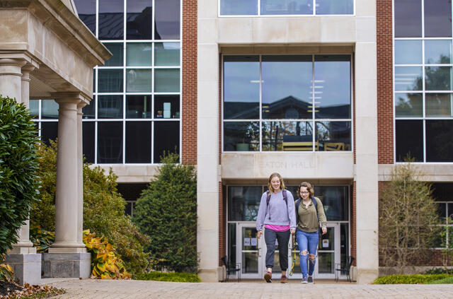 students walk in front of Eaton Hall