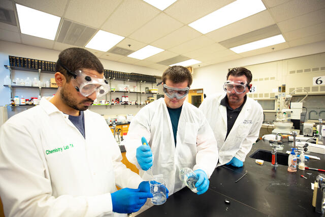 students with professor in chemistry lab