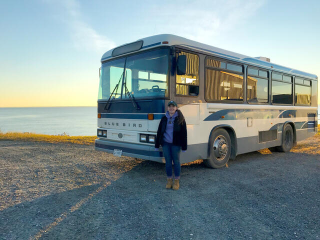 Alumni Caitlin Eversmier in front of the bus she used to provide tours of Hart-Miller Island.