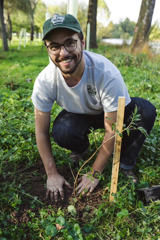 Alum Jason Swartz '18 planting trees in a park.