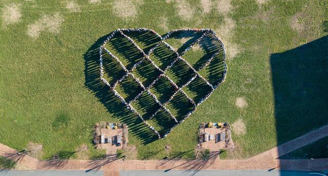 Students at Woodberry Forest School stand in a heart formation, the logo of the One Love Foundation.