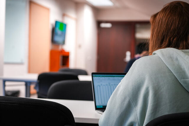 The back of a student seated in the STEM learning center.