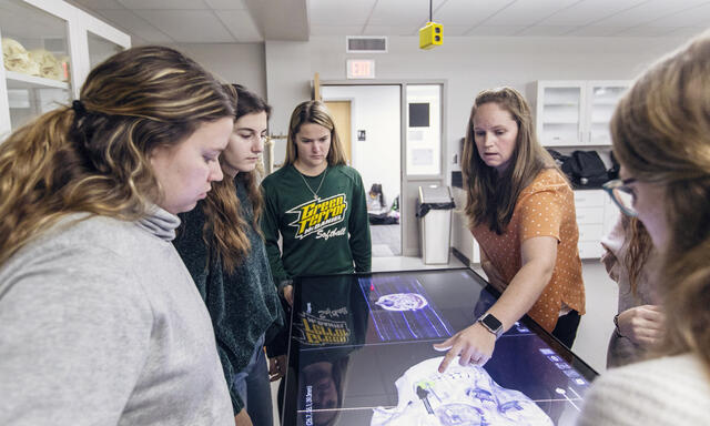 Students using a large touchscreen to view anatomy.