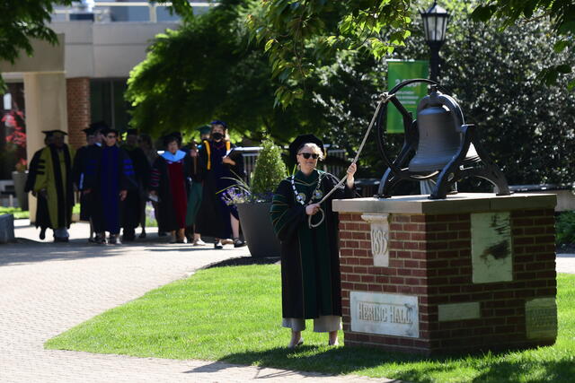 President Jasken rings the memorial bell during the precessional 