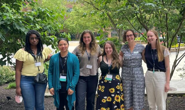 Professor Engle poses with students and alumni at 2022 AESS conference.