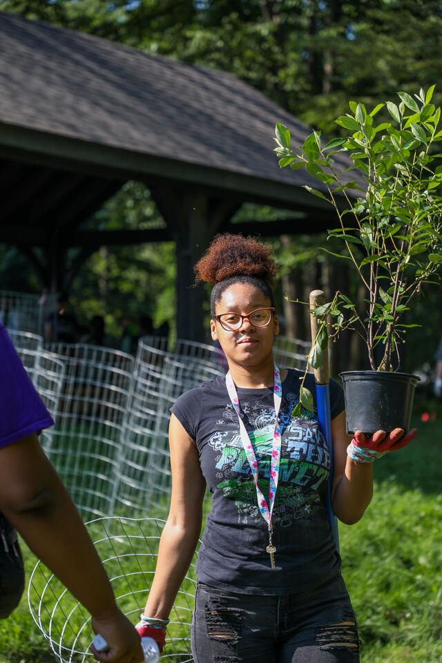 Student holding a sapling at MEC.