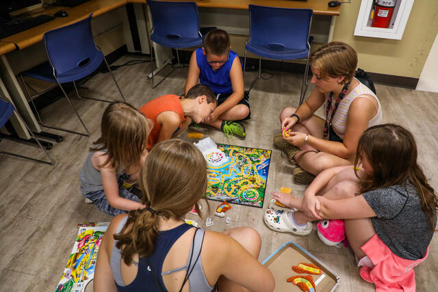 Students playing board games with children at the Boys and Girls Club.