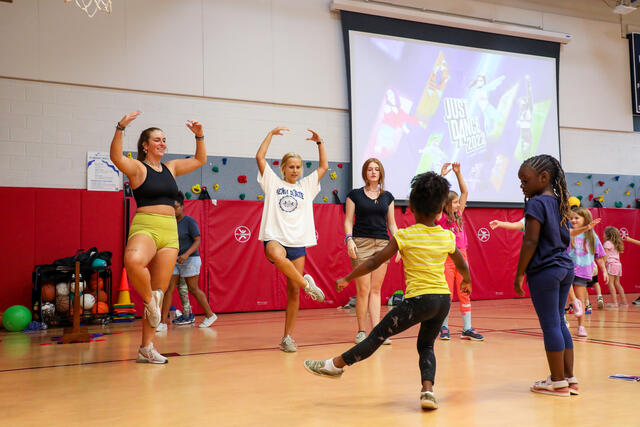 Students dance with kids at Boys and Girls Club.