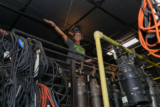 Student Kim Parson backstage with lighting equipment.