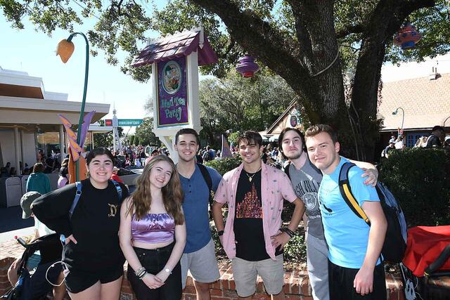 Group of people stand together in amusement park 