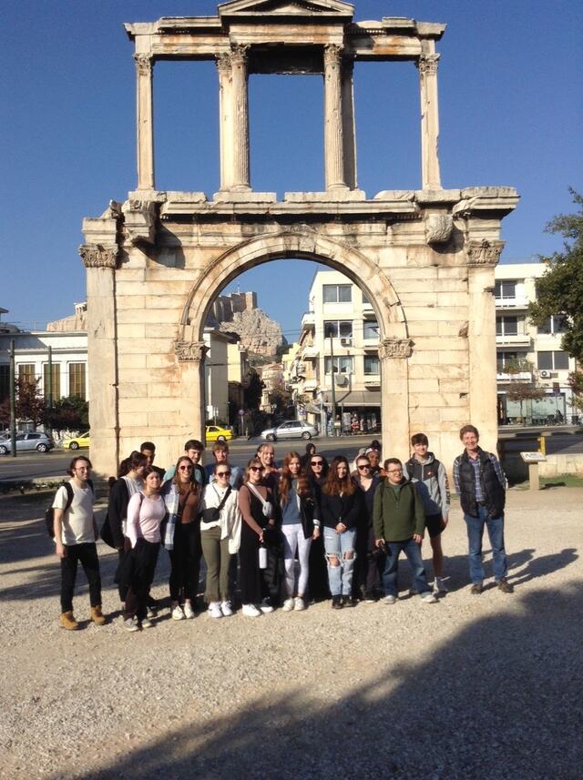 People stand in front of old architecture 