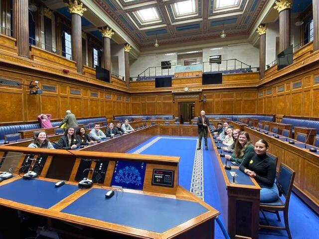 Students sitting in a grand presenting room 