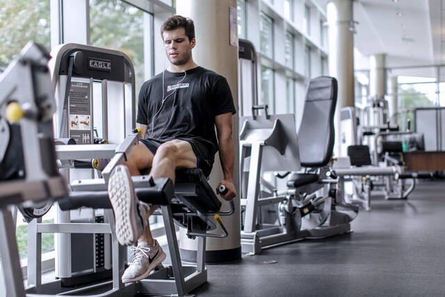 Photo of a student using a weightlifting machine in Merritt Fitness Center.