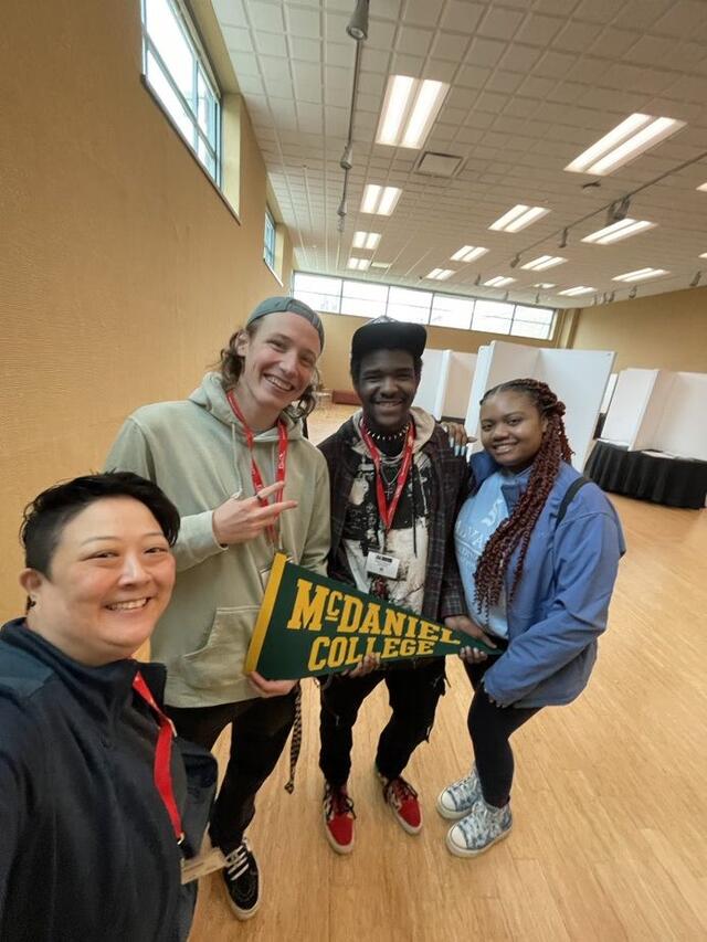 Students standing with a green pennant 