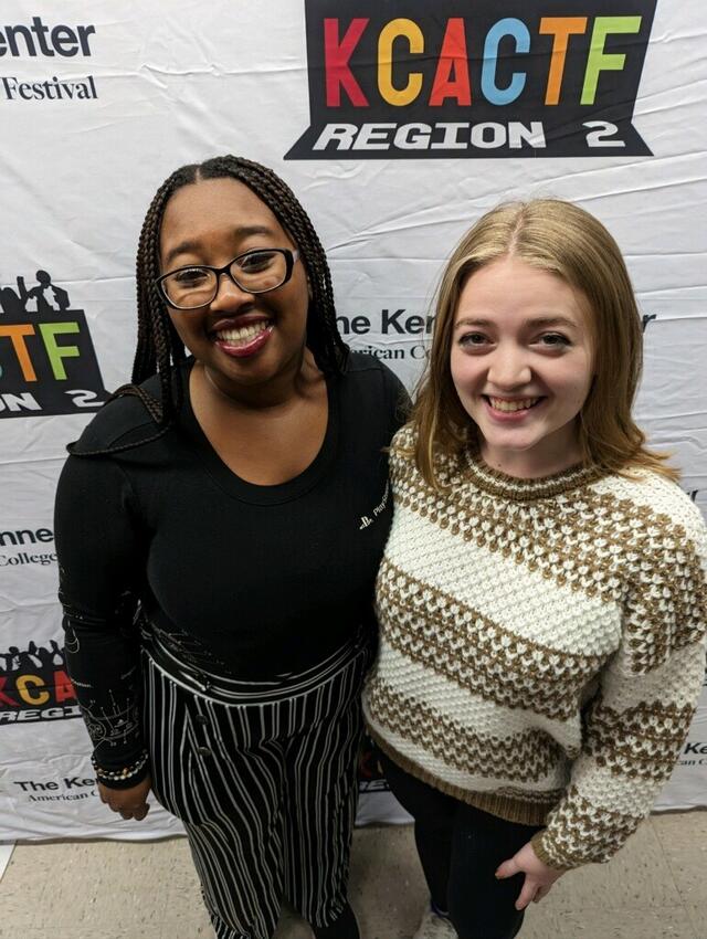 Students standing together in front of backdrop 