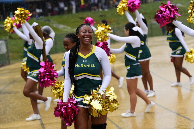 Photo of cheerleaders in McDaniel uniform at a football game.