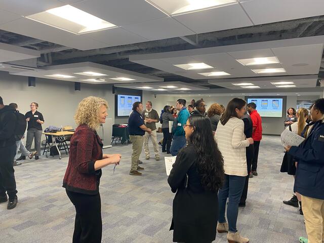 A crowd of people in a large room talking 