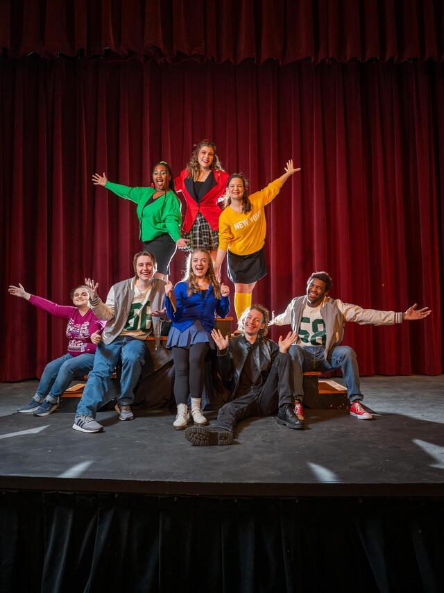 The full cast of Heathers The Musical. They are in vivid colored clothing with happy expressions.