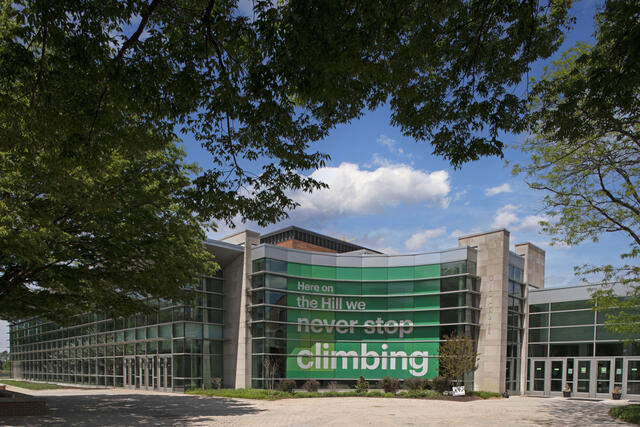 Photo of Merritt Fitness Center with a banner reading "On the Hill we never stop climbing."