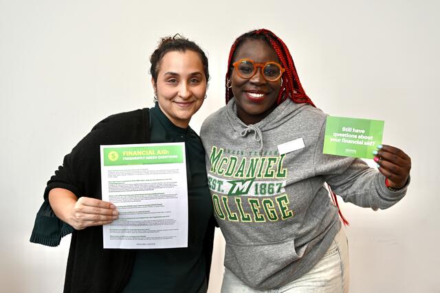 Destiny and Kemia holding signs about Financial Aid