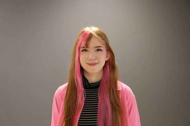 McDaniel student posing in front of grey wall. 