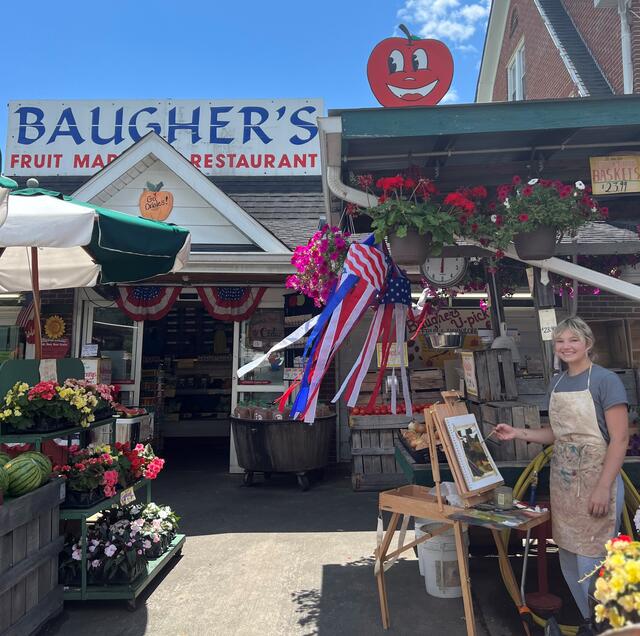 Mandy Smith stands at her easel in front of Baugher's market.