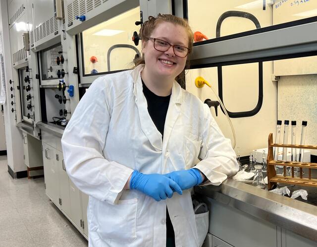 Student Michaela Richardson poses next to test tube samples.
