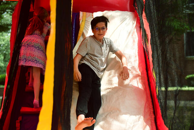 Children sliding in moonbounce at Green Terror for Life Festival Alumni Weekend 2023
